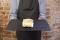 Man holding tray with a raw pastry parcel on Royalty Free Stock Photo