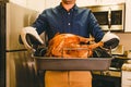 Man holding a tray with roasted crispy turkey, Thanksgiving food preparation Royalty Free Stock Photo