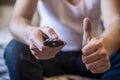 Man holding a tv cable remote control, watching tv. Life style,