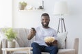 Man holding tv remote controller and popcorn in hands Royalty Free Stock Photo