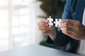 Man holding two jigsaw puzzles put together, business management concept and business risk management. Business solutions, success