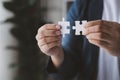 Man holding two jigsaw puzzles put together, business management concept and business risk management. Business solutions, success Royalty Free Stock Photo