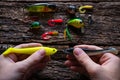 Man holding two lures for fishing with spinning on table Royalty Free Stock Photo