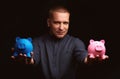 Man holding two piggy banks