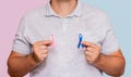 Man holding two Pink and Blue bows for the Pink October and Blue November campaigns to support life and raise awareness about