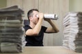 Man holding two twisted roll newspaper. Metaphor or allegory with binoculars. Selective focus on the face Royalty Free Stock Photo