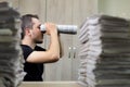 Man holding two twisted roll newspaper. Metaphor or allegory with binoculars. Selective focus on the face