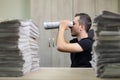 Man holding two twisted roll newspaper. Metaphor or allegory with binoculars. Selective focus on the face Royalty Free Stock Photo