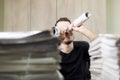 Man holding two twisted roll newspaper. Metaphor or allegory with binoculars. Selective focus on newspapers