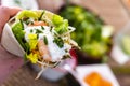 man holding typical Mexican fajita with shrimp and vegetables