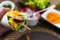 man holding typical Mexican fajita with shrimp and vegetables