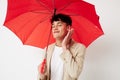 Man holding an umbrella in the hands of posing fashion light background unaltered Royalty Free Stock Photo