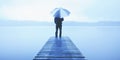 Man Holding an Umbrella on a Jetty by Tranquil Lake Concept