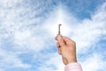 Man holding up key against bright sky Royalty Free Stock Photo