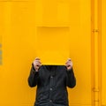 A man holding up a sheet of yellow paper. Royalty Free Stock Photo