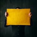A man holding up a sheet of yellow paper. Royalty Free Stock Photo