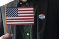 Man holding USA flag with I Voted Today sticker one coat lapel Royalty Free Stock Photo