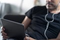 Man holding using digital tablet and headphones sitting on a sofa. Online education, working, video call