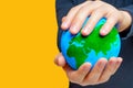 Man Holding Verdant Globe on Yellow Background Royalty Free Stock Photo