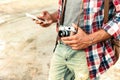 Man holding vintage photo camera and using mobile phone Royalty Free Stock Photo