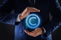 Man holding virtual icon of copyright symbol on dark background, closeup Royalty Free Stock Photo