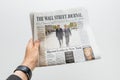 Man holding The Wall Street Journal newspaper with Emmanuel Macron on first page cover