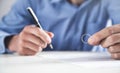 Man holding a wedding ring and signing divorce contract