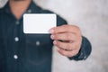 Man holding white business card on concrete wall background Royalty Free Stock Photo