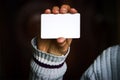 Man holding white business card on concrete wall background Royalty Free Stock Photo