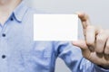 Man holding white business card on concrete wall background Royalty Free Stock Photo