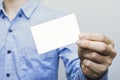 Man holding white business card on concrete wall background,mockup template Royalty Free Stock Photo