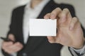 Man holding white business card,Man wearing white shirt and showing blank white business card. Blurred background. Horizontal mock