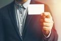 Man holding white business card,Man wearing blue shirt and showing blank white business card. Blurred background. Horizontal mocku