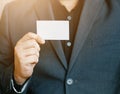 Man holding white business card,Man wearing blue shirt and showing blank white business card. Blurred background. Horizontal mocku