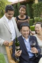 Man Holding Wine Bottle And Glass With Friends In Park Royalty Free Stock Photo