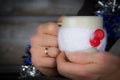 Man holding winter cup close up on blurred background. man hands holding a cozy mug with hot cocoa, tea or coffee Royalty Free Stock Photo