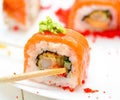 Man holding wooden chopsticks sushin, on top of wasabi sushi. white background