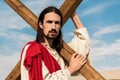 Man holding wooden cross against blue sky Royalty Free Stock Photo