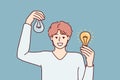 Man holding working and broken light bulbs to show off self-made electricity repair Royalty Free Stock Photo