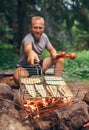 Man holds above fire grilling with sliced vegetables. Summer pic Royalty Free Stock Photo