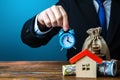 A man holds an alarm clock over the house and money. Limited offer. Rental business. Favorable terms and conditions, low interest Royalty Free Stock Photo
