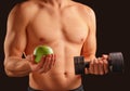 Man holds apple and dumbbell Royalty Free Stock Photo