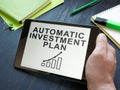 Man holds automatic investment plan AIP in the tablet. Royalty Free Stock Photo