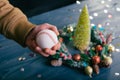 A man holds a baseball ball against the background with decoration on a wooden table. Festive composition for new year and Royalty Free Stock Photo