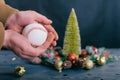 A man holds a baseball ball against the background with decoration on a wooden table. Festive composition for new year and Royalty Free Stock Photo