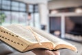 A man holds a Bible against the background of the living room. Reading a book in a cozy atmosphere Royalty Free Stock Photo