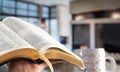 A man holds a Bible against the background of the living room. Reading a book in a cozy atmosphere Royalty Free Stock Photo