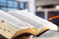 A man holds a Bible with a pencil, against the background of the living room. Reading a book in a cozy atmosphere Royalty Free Stock Photo