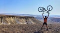 Man holds bicycle on a peak