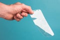 Man holds broken, broken smartphone safety glass in hand on blue background. concept of fragile equipment